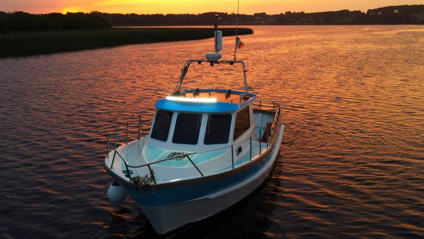 The Hot Tub Boat cruising the river with the sunset in the back ground