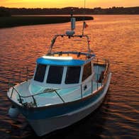 The Hot Tub Boat cruising the river with the sunset in the back ground