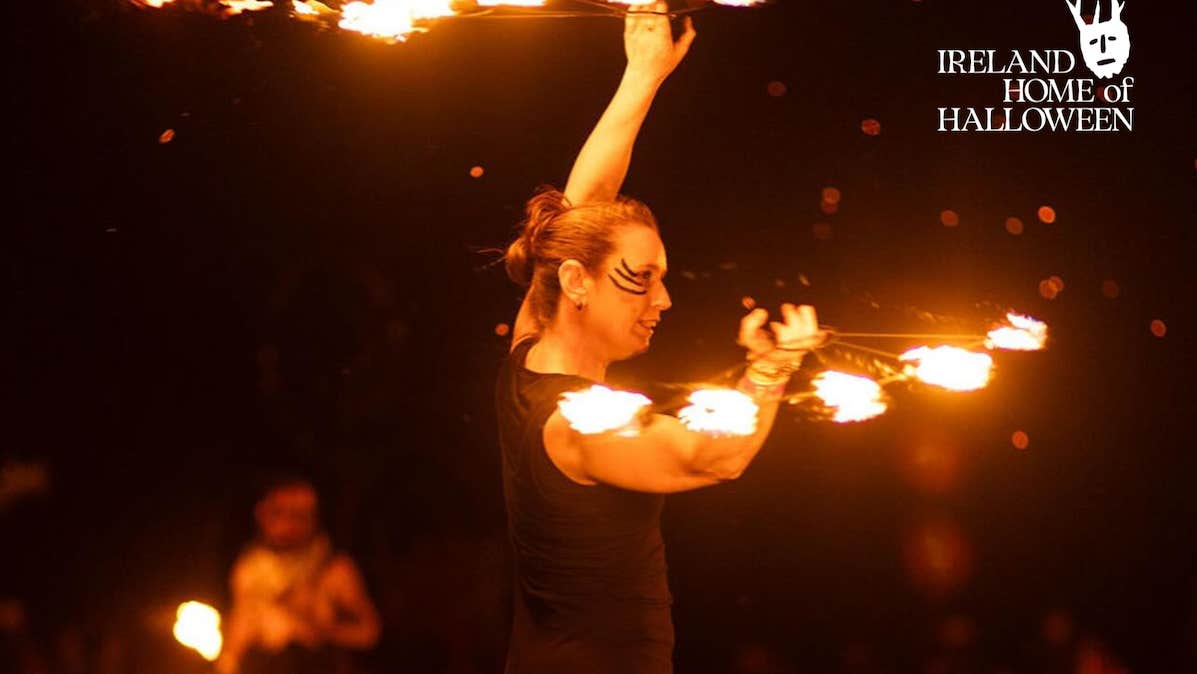 Skerries Fire Show Spectacular - a person at night is twirling around batons with the ends on fire.