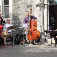 Small group of musicians performing in front of an old front door