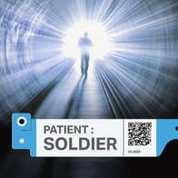 A dark tunnel with a silhouette of a figure walking down it towards a bright light