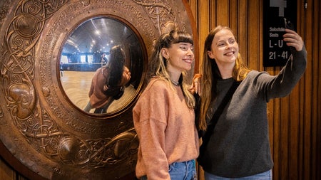 Two ladies taking a photograph at the copper wall mirror at the Abbey Theatre