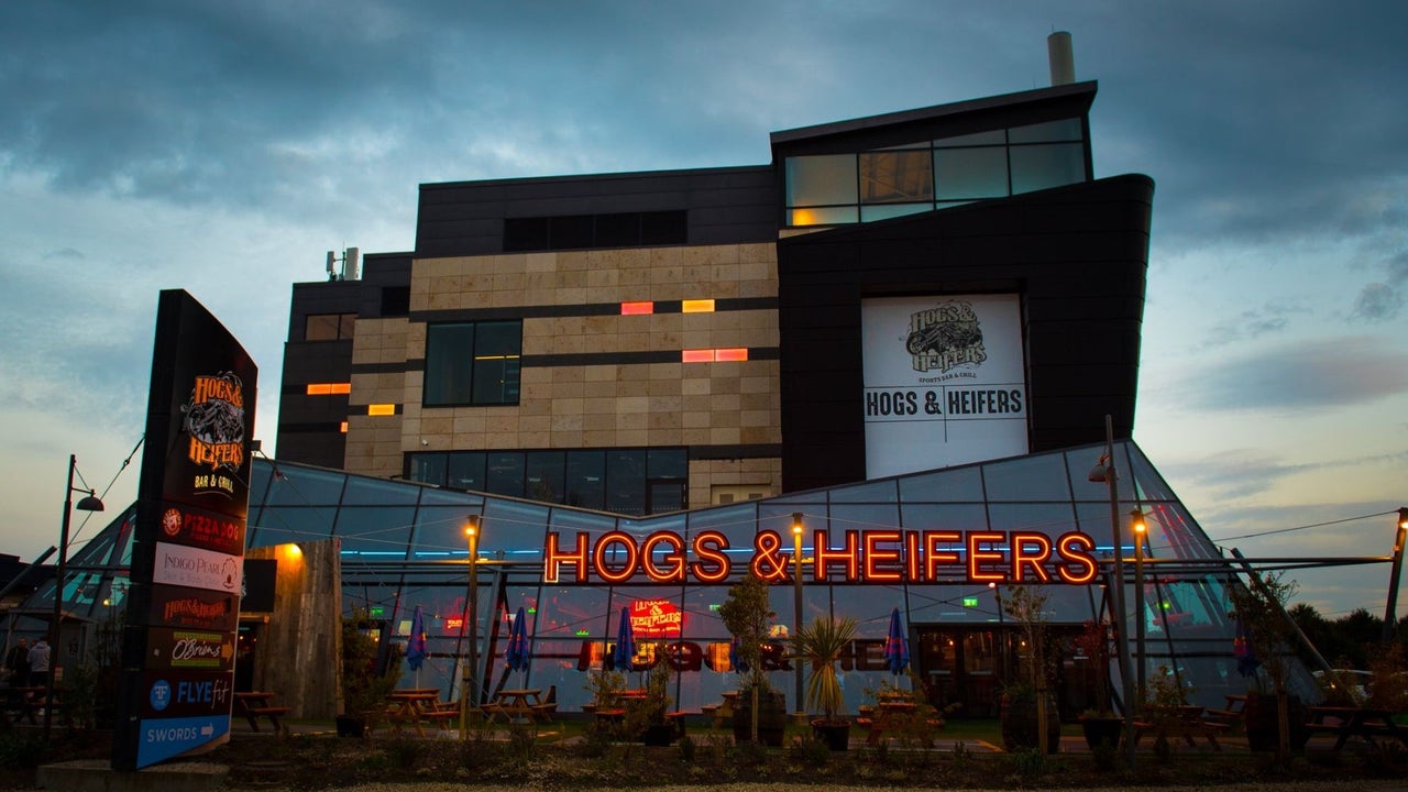 Glass exterior of a pub with the name displayed in neon lights