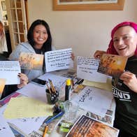 Three girls holding up cards with Irish calligraphy on them