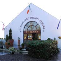 White building with an arched entrance and landscaped gardens