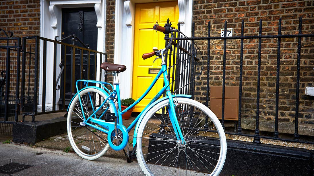 A blue bicycle outside a yellow door in Dublin City Centre