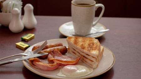 Plate with toast and a fry on it and a large white mug in the background