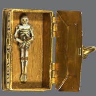 Shadows of Samhain Halloween. A small figure of a skeleton in an old gold box.