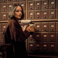 A woman looking over her shoulder while using a card catalogue.