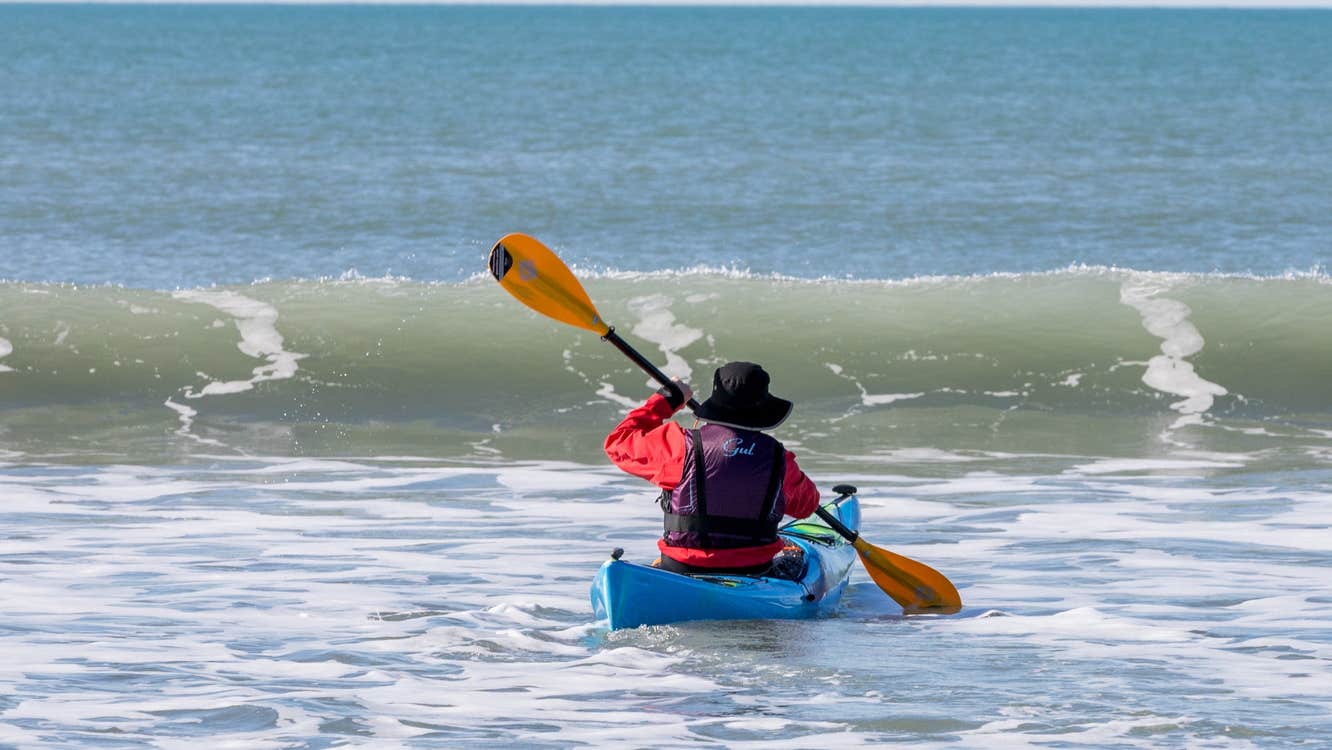A man kayaking at Garrylucas White Strand beach