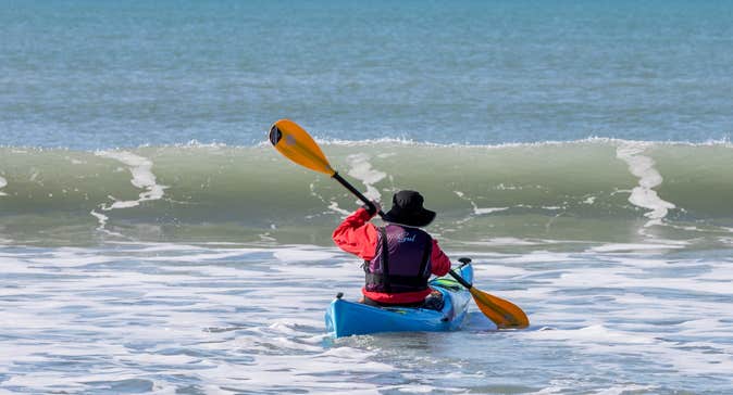 A man kayaking at Garrylucas White Strand beach