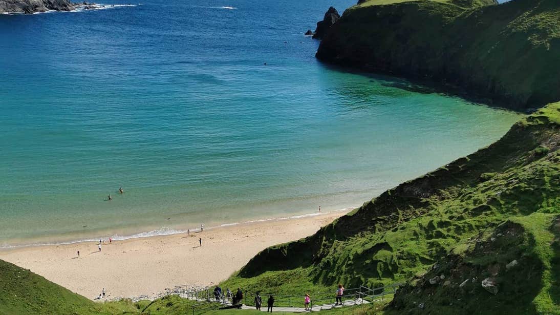 People walking down the steps to the beach at Malin Beg, Donegal
