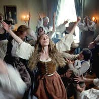 People in 18th Century clothing are dancing wildly.