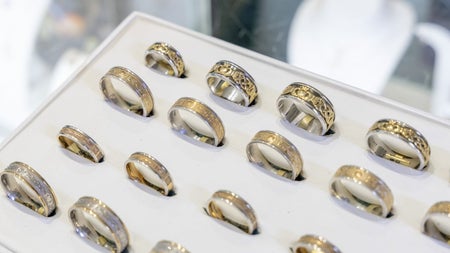 A display case with gold and silver Celtic rings