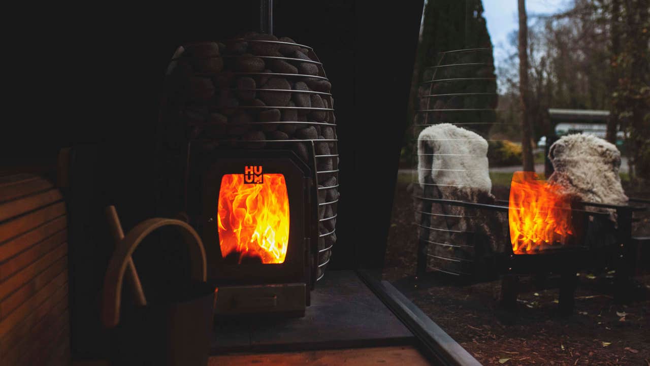 Fire for the sauna with bright flames reflected in the window
