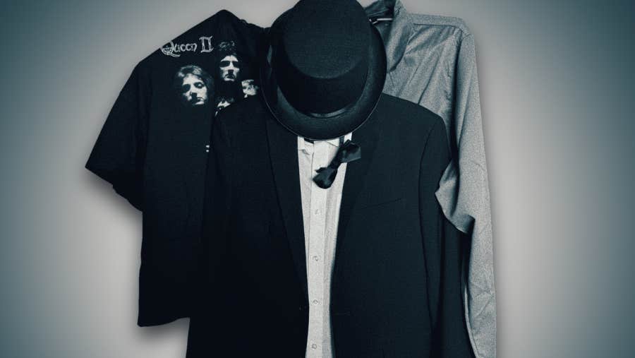 3 hangers on a wall with items of clothing on.