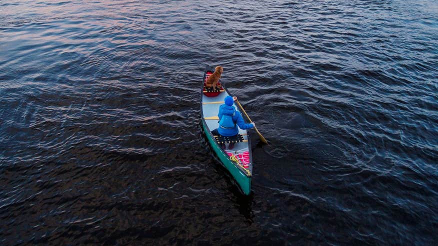 A woman paddling with a dog on Lough Derg.