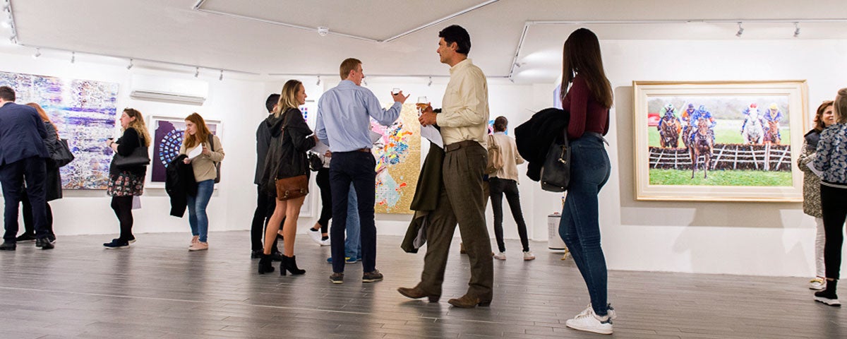 People milling around the gallery exploring the exhibition of works