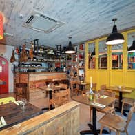 The interior of Cava Bodega restaurant featuring warm wooden furnishings and shelves of wine and books