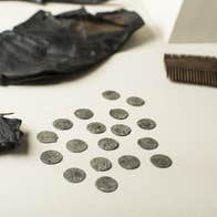Viking coins spread over a tables from a leather pouch