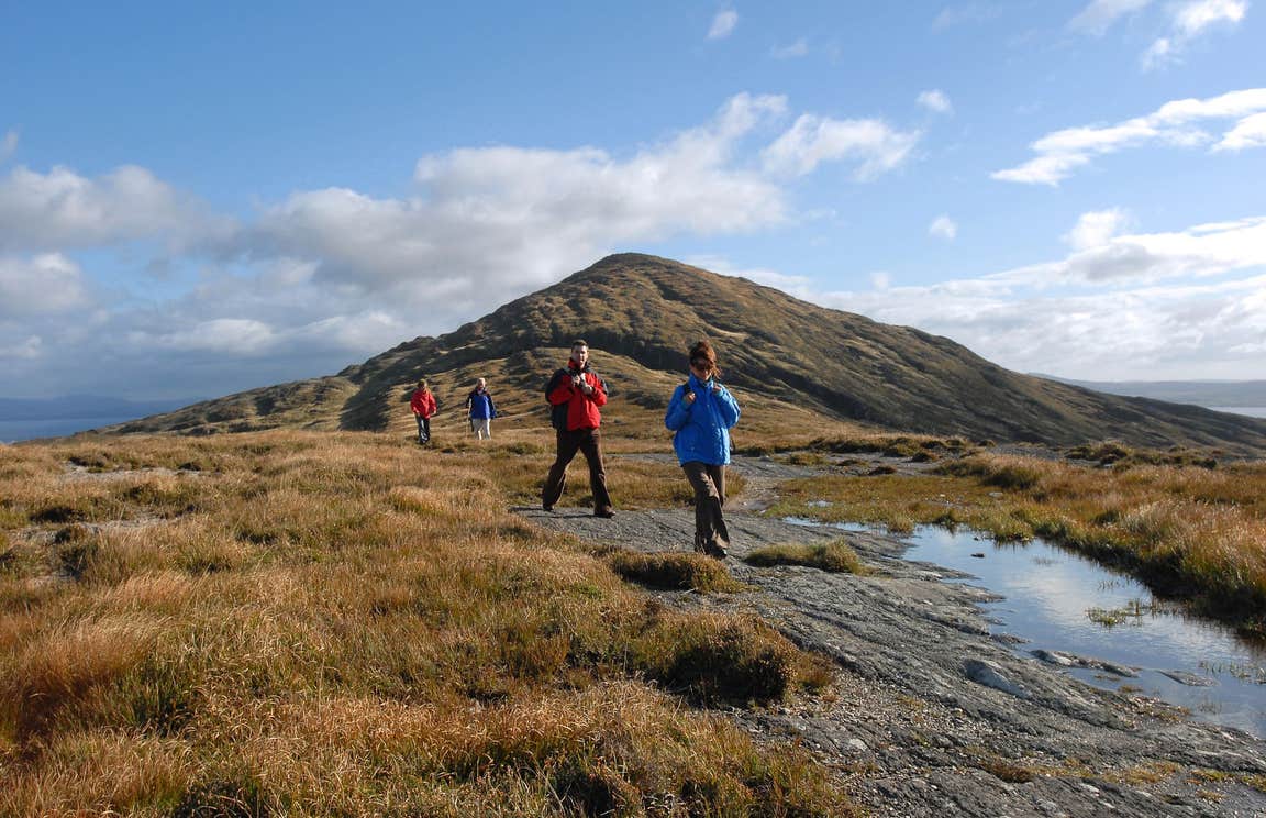 People walking at the base of a mountain on Sheep's Head, Cork