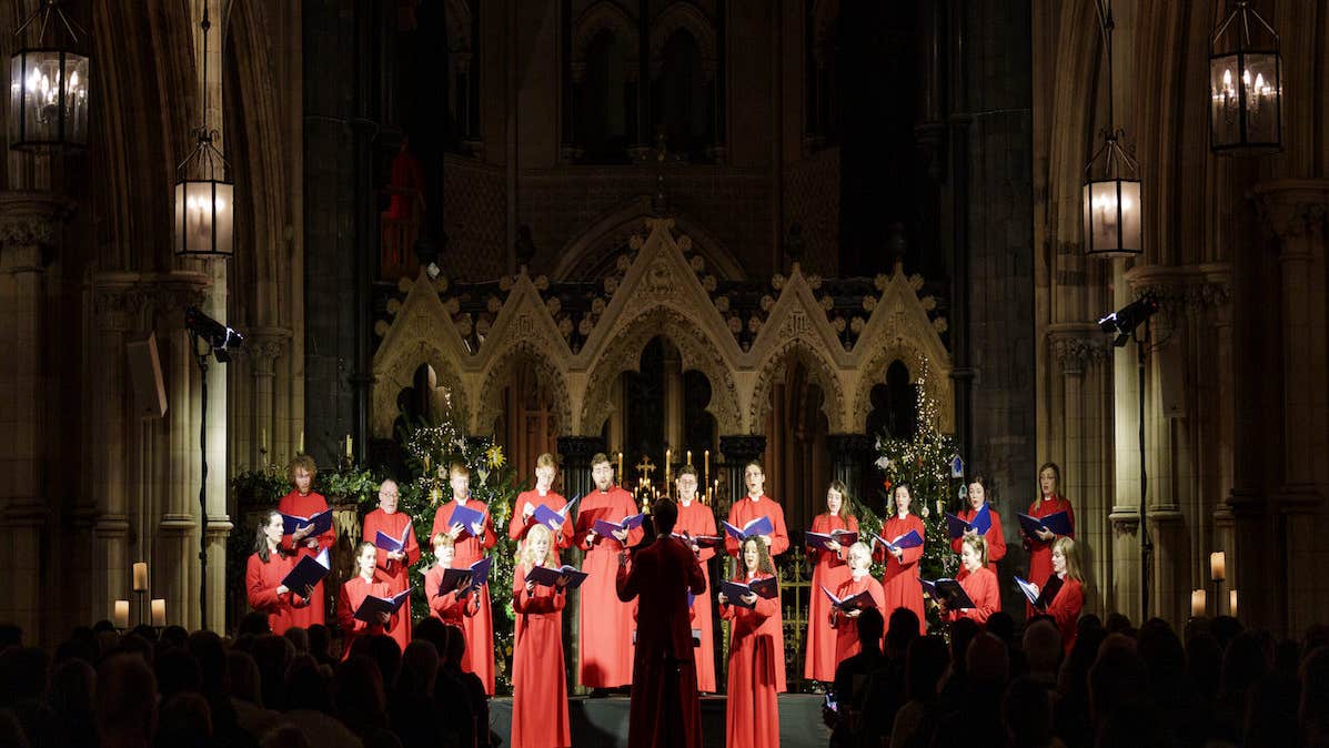 Christmas with Christ Church Cathedral choir, dressed in long red gowns standing in front of an alter
