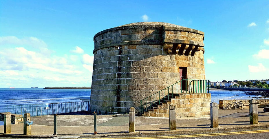 Martello tower with blue sea and blue and white clouds in the background