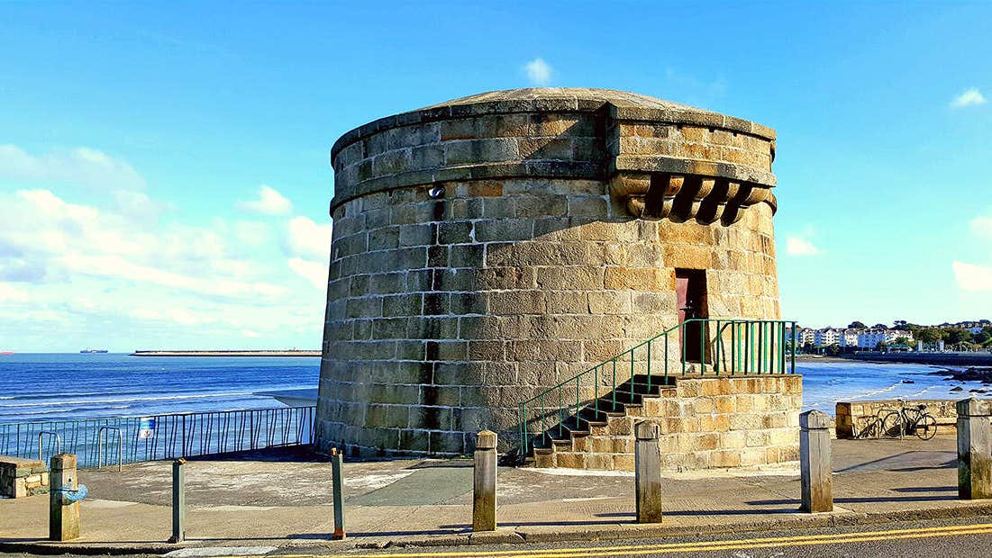 Martello tower with blue sea and blue and white clouds in the background