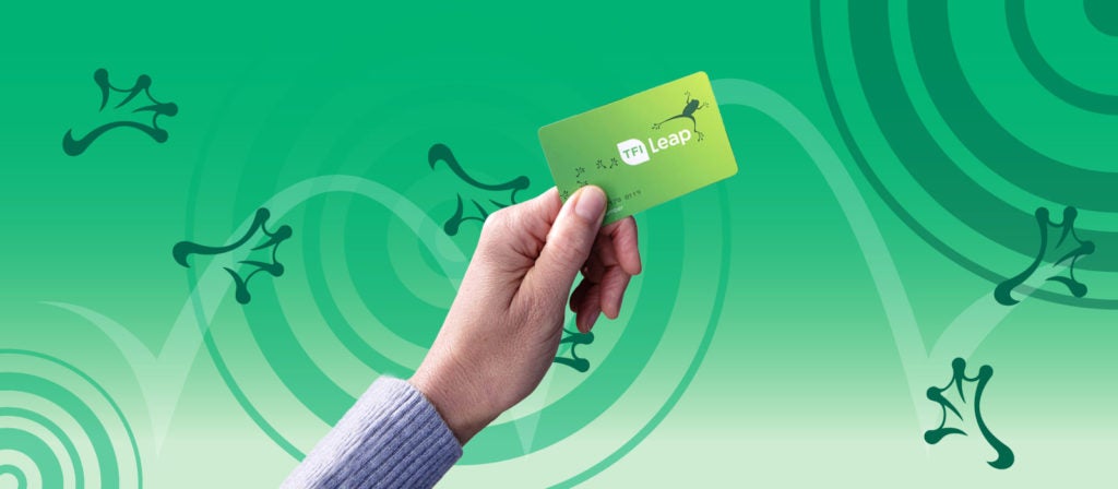 Person holding green TFI leap card that has a dark green frog on it