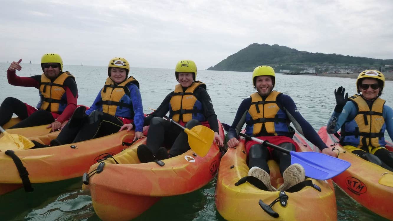 Five people in kayaks lined up side by side