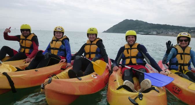 Five people in kayaks lined up side by side