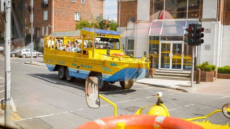 A land boat with passengers on a city street