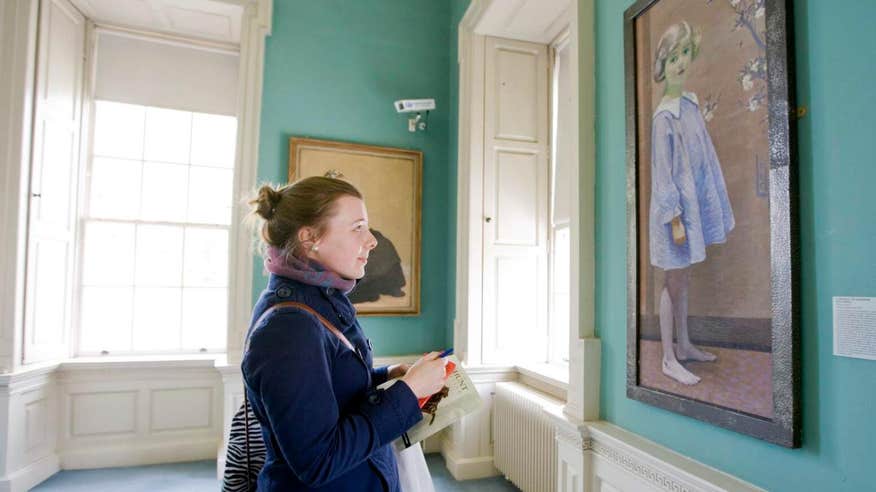 Woman admiring a painting of a young girl at The Hunt Museum in Limerick