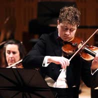Patrick Rafter playing the violin in concert attire.