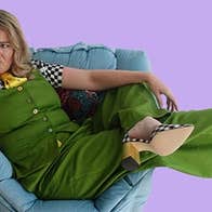 A person looking confused is laying across a soft chair.