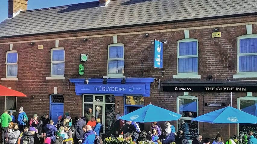 The Glyde Inn Beachside Bar & Restaurant exterior with umbrellas and people