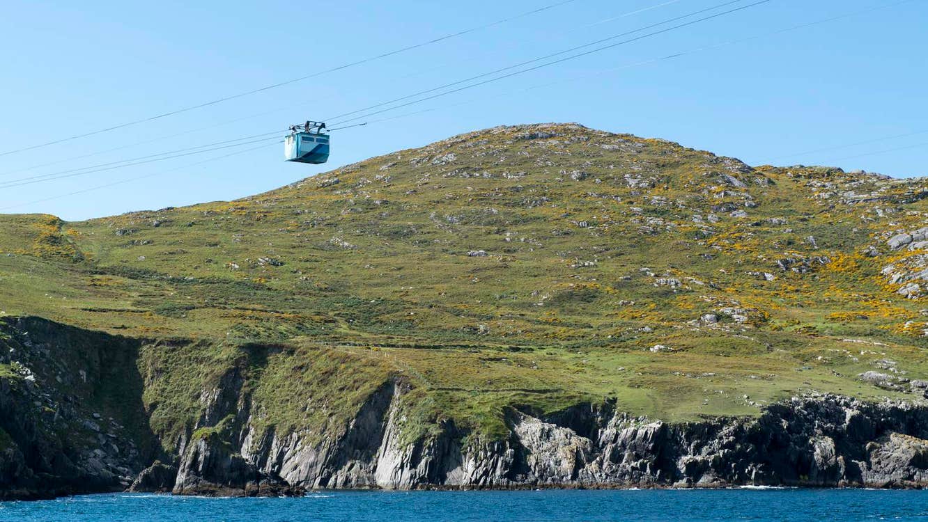 Cable car with land in the background and sea underneath