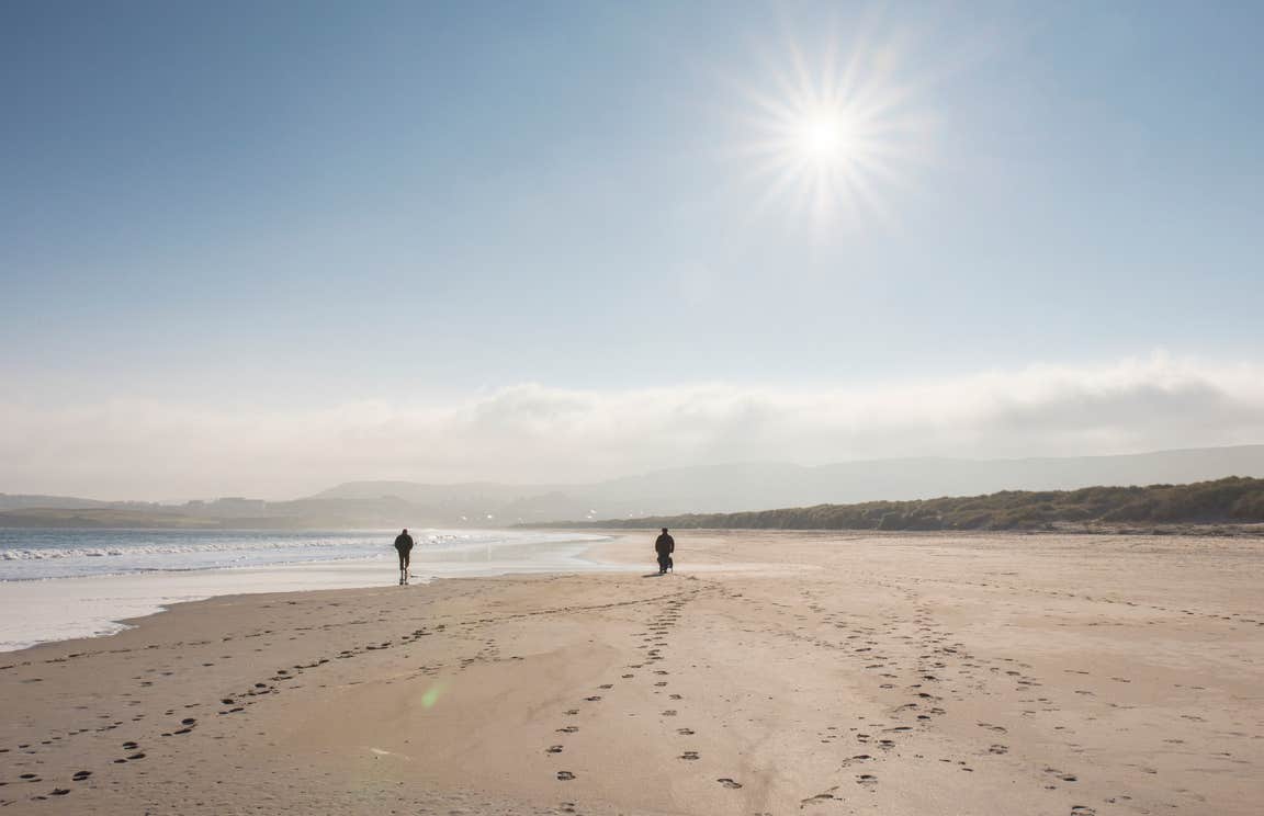 Two people walking on Killahoey Beach in Dunfanaghy, County Donegal
