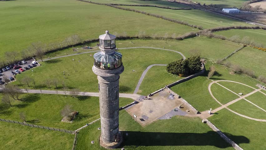 An aerial view of a tall tower with a glass observation platform at the top
