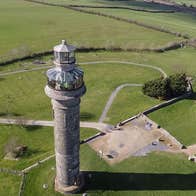 An aerial view of a tall tower with a glass observation platform at the top