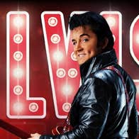 A man in leather jacket with a guitar is looking back over his left shoulder with large illuminated name behind.