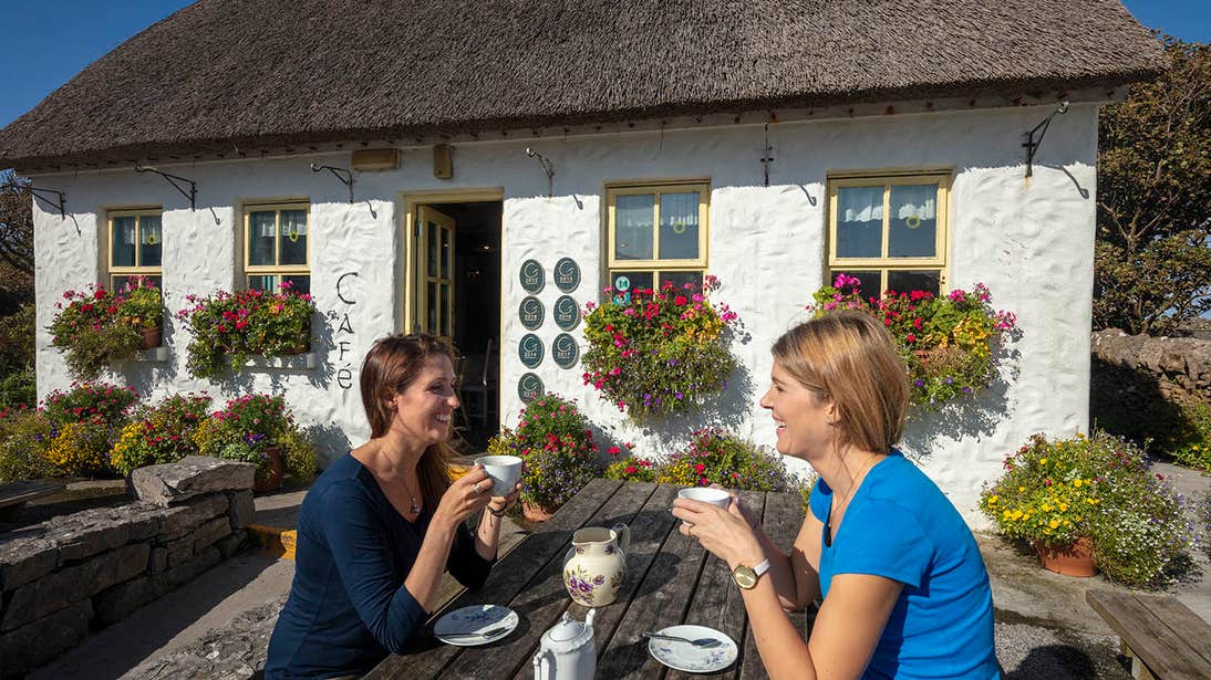 Two people enjoying a cup of tea outside Teach Nan Phaidi, Inishmore, Aran Islands, Galway