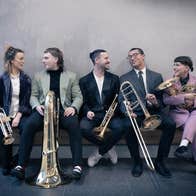 5 young brass musicians with their instruments
