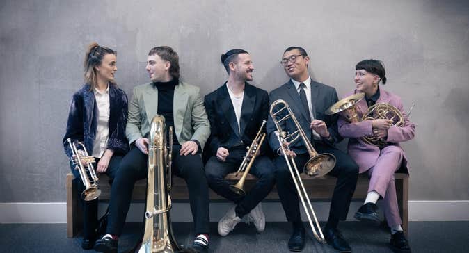 5 young brass musicians with their instruments