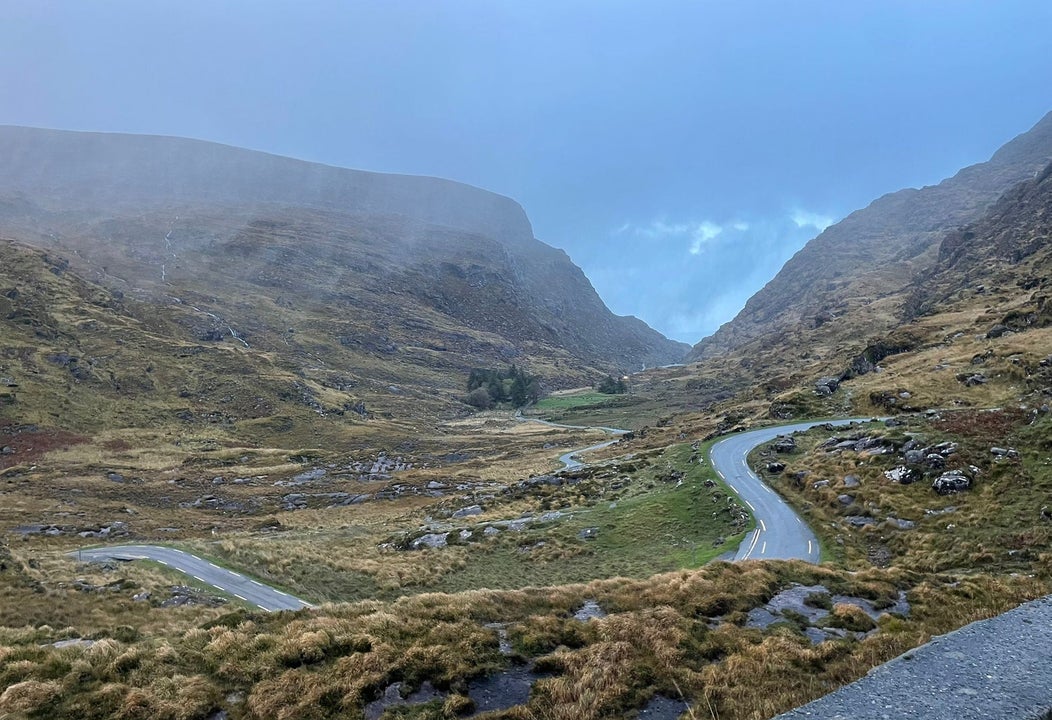 Small road through rocky landscape with mountains in the background