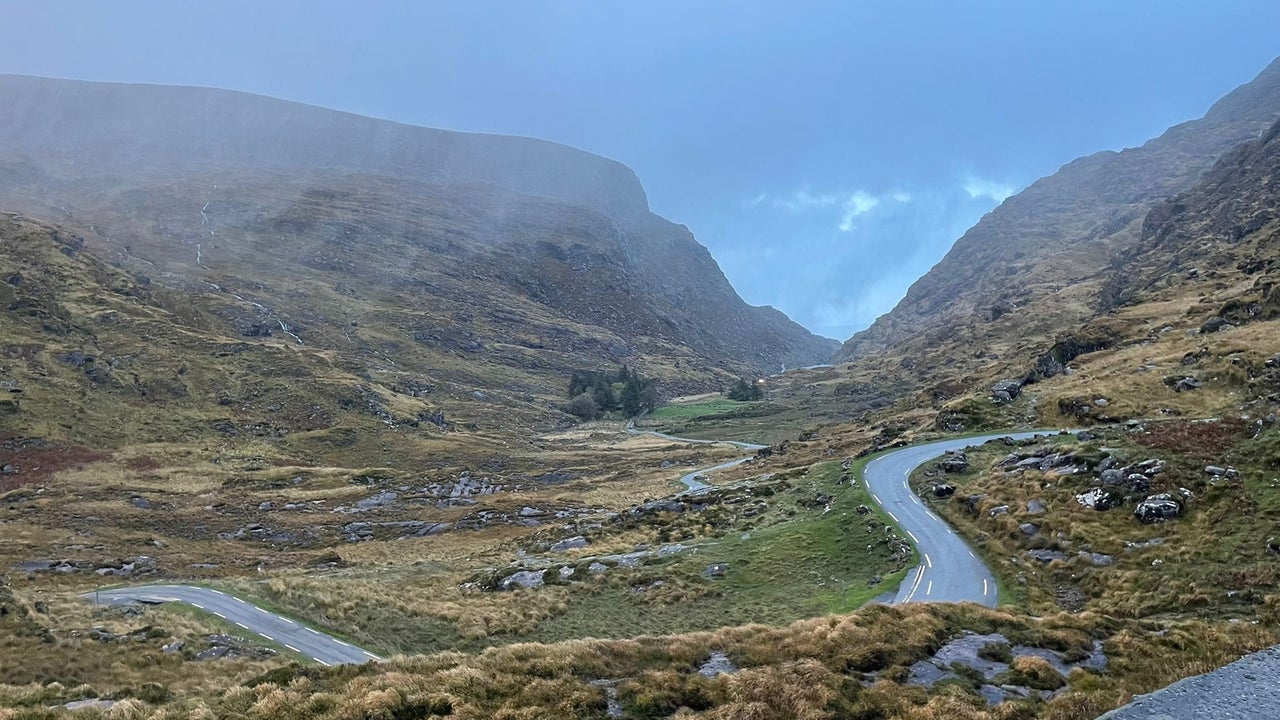 Small road through rocky landscape with mountains in the background