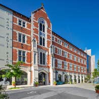 Exterior of red brick former convent building with some trees nearby