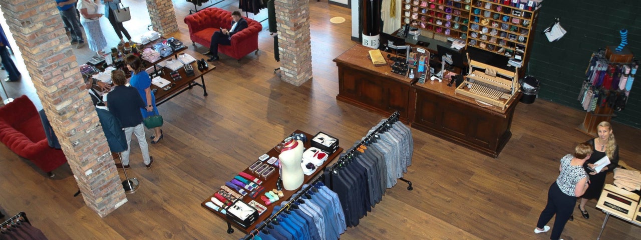 The interior of Celtic Tweed with customers inside the shop and tailored suit jackets on the display racks