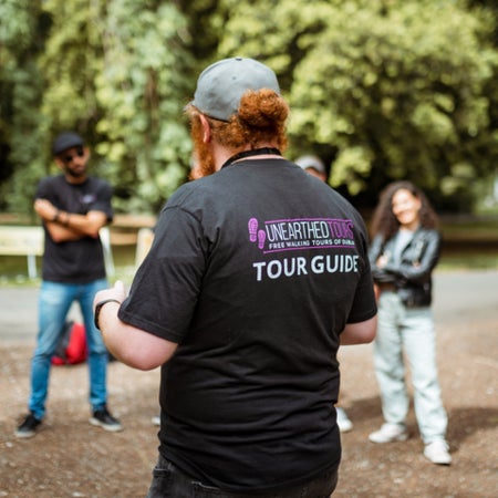 A guide wearing branded clothing of a tour company while giving a tour