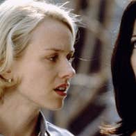 A woman is talking to another woman close beside her who is looking upwards.